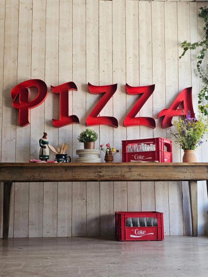 Anciennes lettres d'enseigne industrielles en métal formant le mot PIZZA